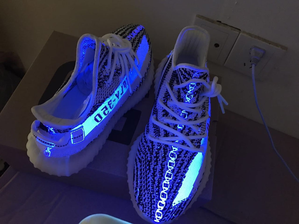 Yeezy 350 V2 Glow-in-the-Dark Sneakers, in Black and White - product image from the listing.