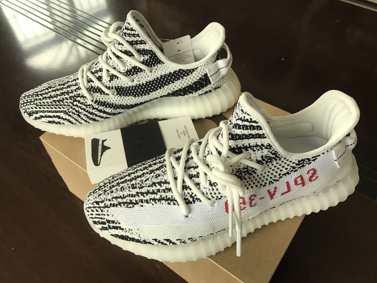 Yeezy 350 V2 Glow-in-the-Dark Sneakers, in Black and White - product image from the listing.
