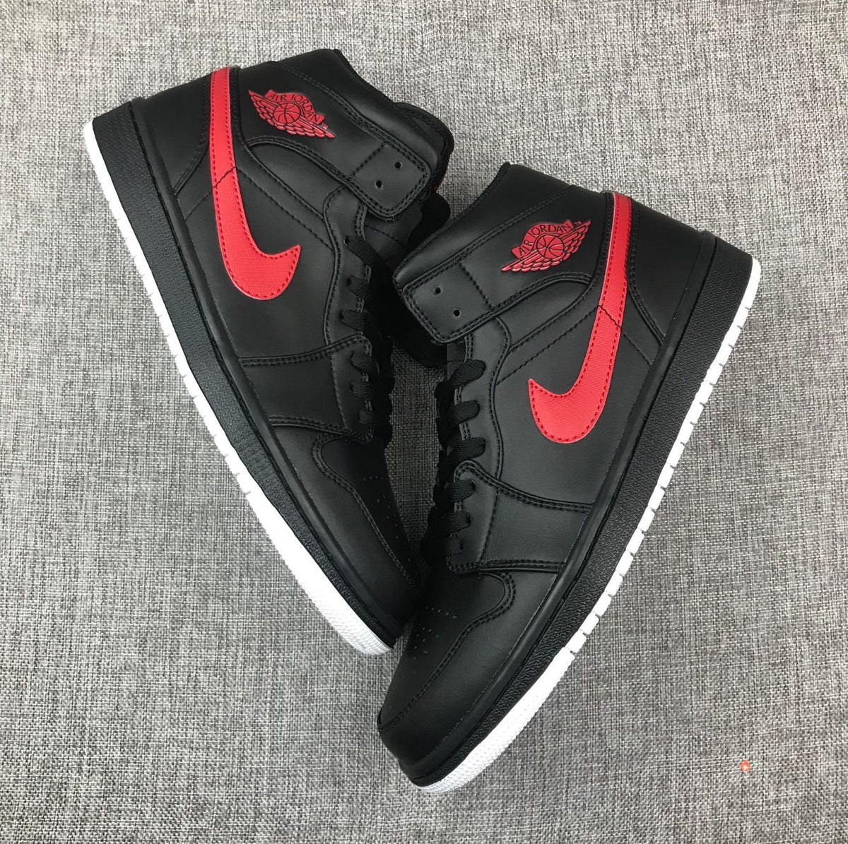 Air Jordan 1 Mid Sneakers in Black and Red 554724-045 - product image from the listing.